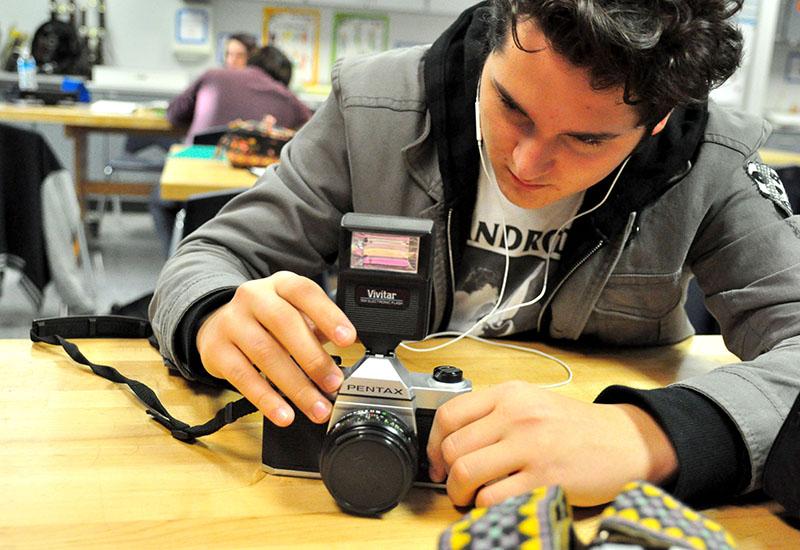 Sophomore David Sosa works with his film camera in Photography 2.