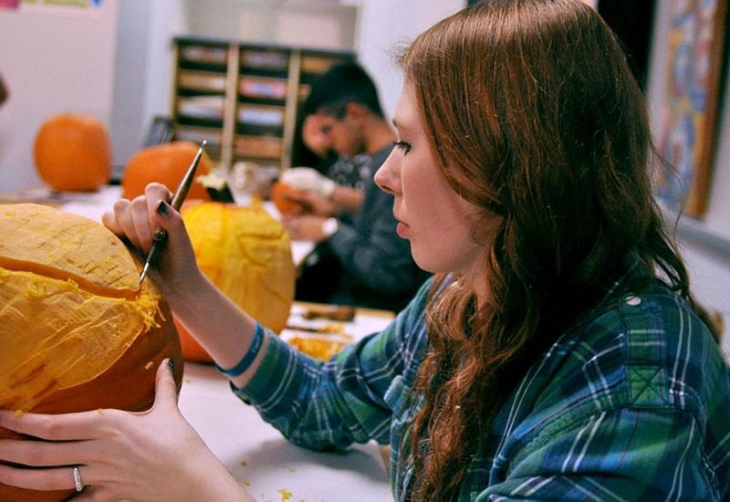 Miranda Morris carves a pumpkin in her art class for a Halloween decoration.
