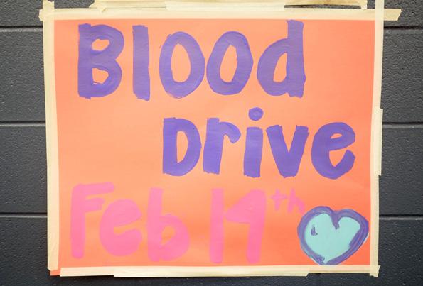 Student council members work to make this years blood drive a success by hanging various posters around the campus.