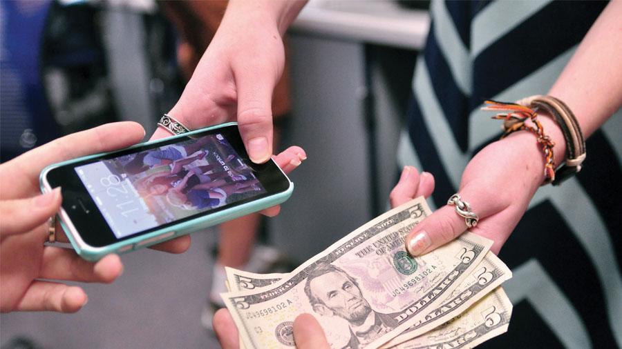 A student exchanges her phone for  $15, the standard fee.
