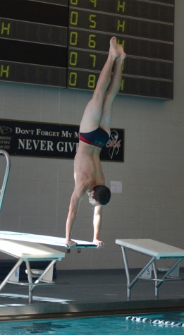 Senior Max Finnegan does a handstand on the diving board, preparing for his next dive.