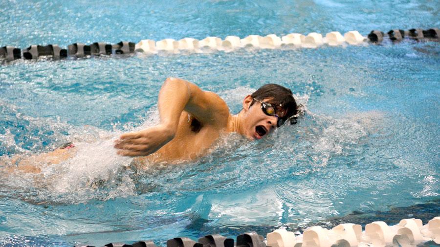 Warming up for practice, junior Christopher Lestage swims at a leisurely pace.