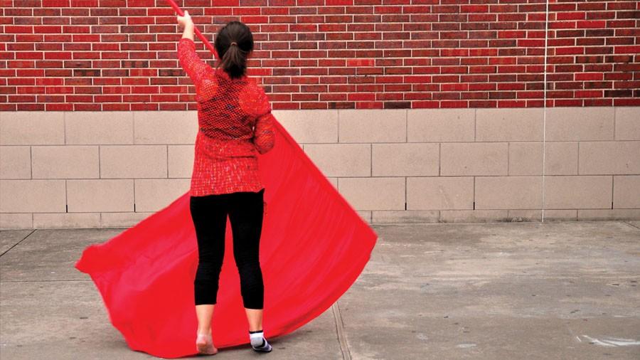 An avid member of the colorguard, sophomore Hannah McMurray, practices her dancing outside the school. 