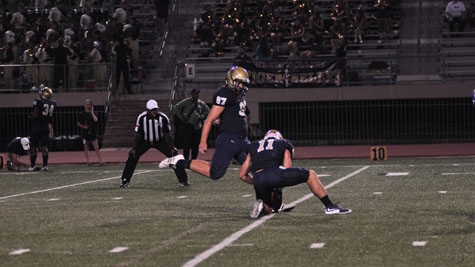 Junior Scott Bazemore kicks the ball at a football game.