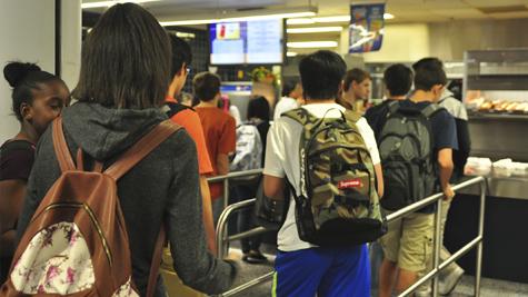 Students stand in the lunch line while waiting on their turn in line.