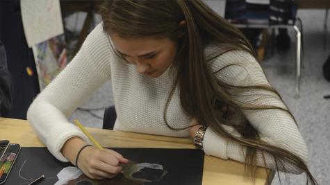 Junior Haley Durst colors in a piece for possible submission for the Scholastic Art & Writing Awards.
