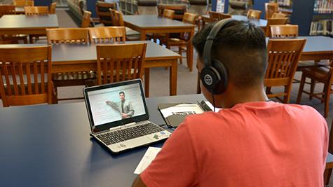 Junior Gabriel Gomez watches a lesson in the library at his own pace, a benefit of blended classes.