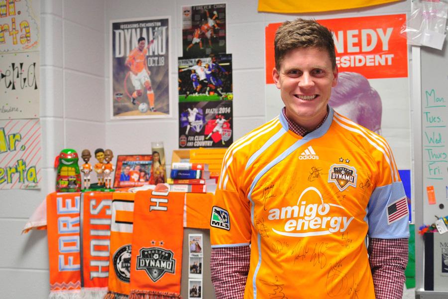 4. U.S. History teacher Gordon Berta poses in front of his collection of Dynamo gear. This collection includes bobble heads, posters, scarves, a mug and the jersey he is wearing.