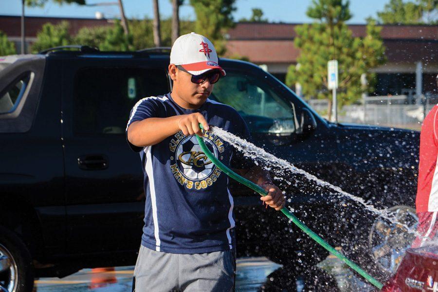 Junior Anthony Lopez washes a car for the annual soccer fundraiser. $1,800 was raised.