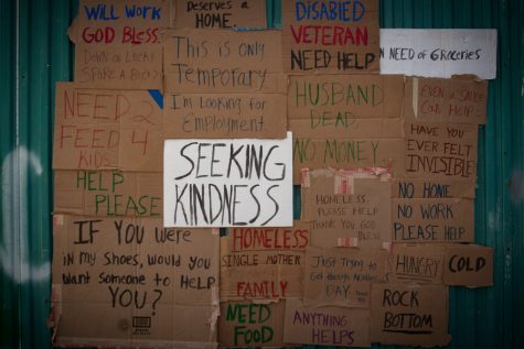 A collection of cardboard signs that identify some of the struggles of living poverty. 
