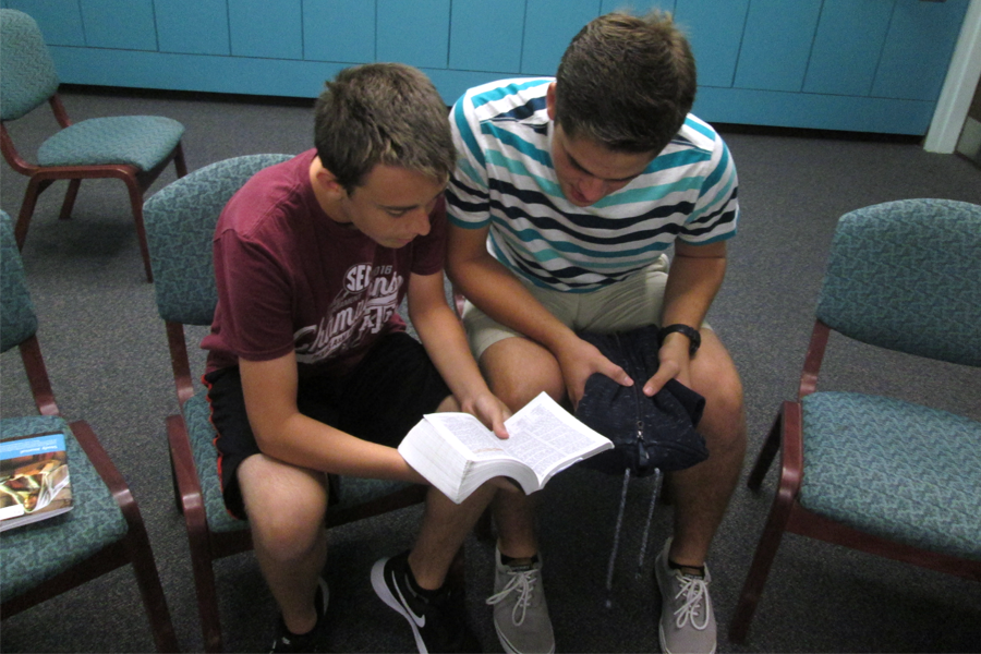 Sophomore Ryan Del Papa and junior Scott Brighton read from the scriptures before seminary starts.