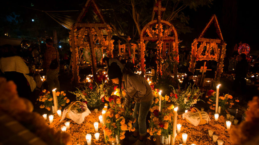 Flowers and candles set the mood during a Day of the Dead vigil at a cemetery in Oaxaca, Mexico.