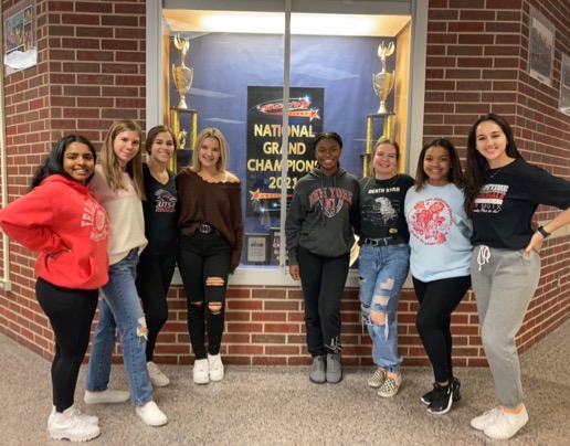 The Klein Collins Tiger Belles pose proudly in front of their trophy case.