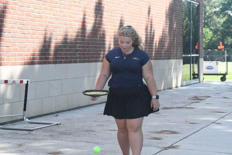 Megan Hardin, sophomore practices her skills while walking to the courts. 